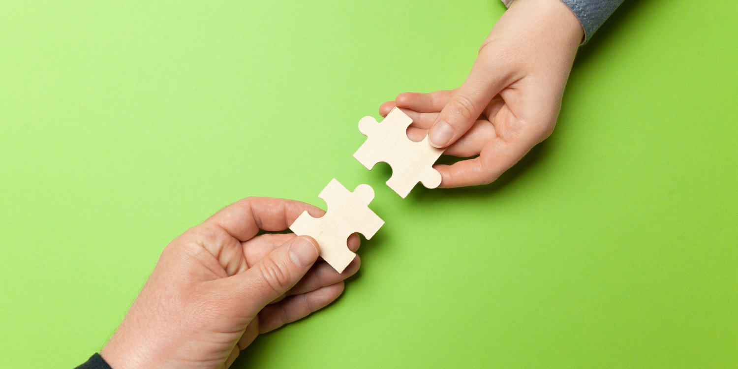hands holding puzzle pieces depicting collaboration and integration