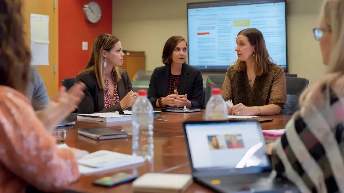 Modern nonprofit office with Salesforce applications displayed on multiple devices
